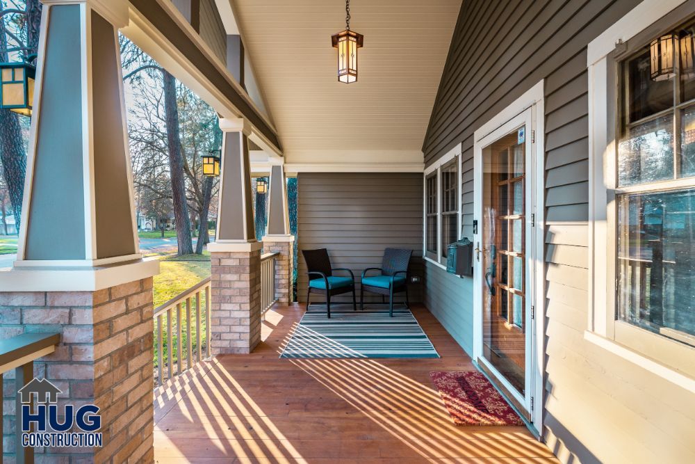 Spacious porch remodels with comfortable seating, warm lighting, and wooden flooring at dusk.