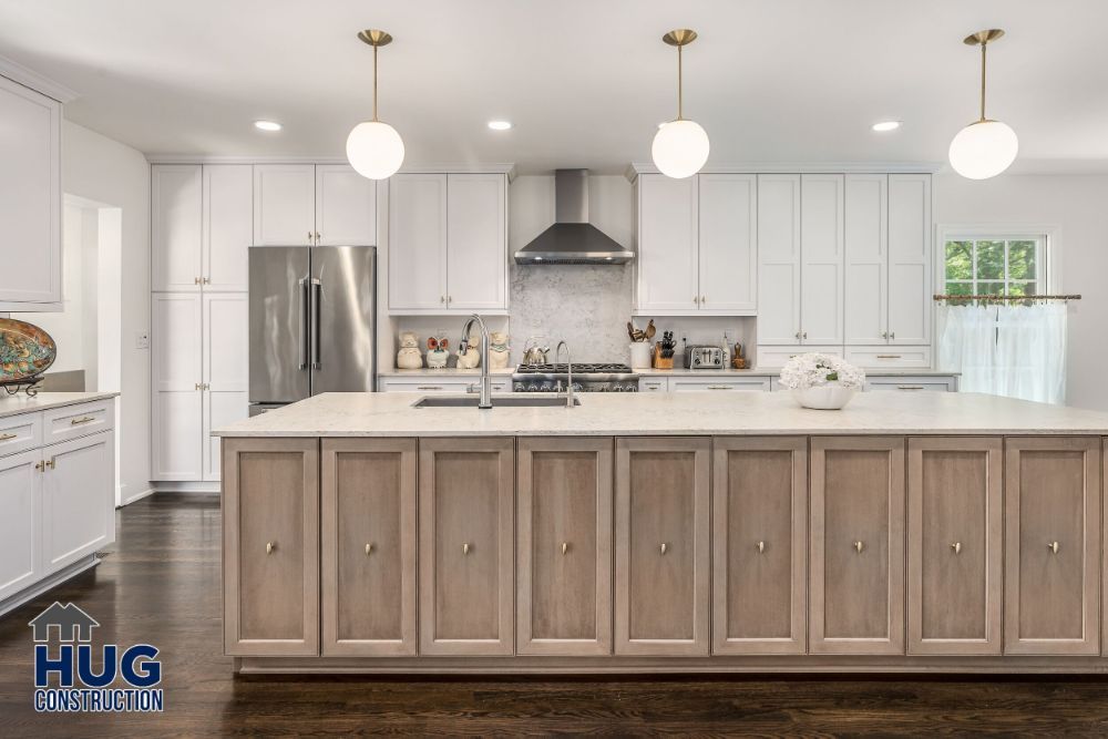 Modern kitchen interior with white cabinets, a central island, and recent remodels.