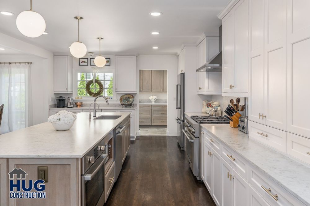 Modern kitchen interior with white cabinetry, stainless steel appliances, and a central island featuring recent remodels and additions.