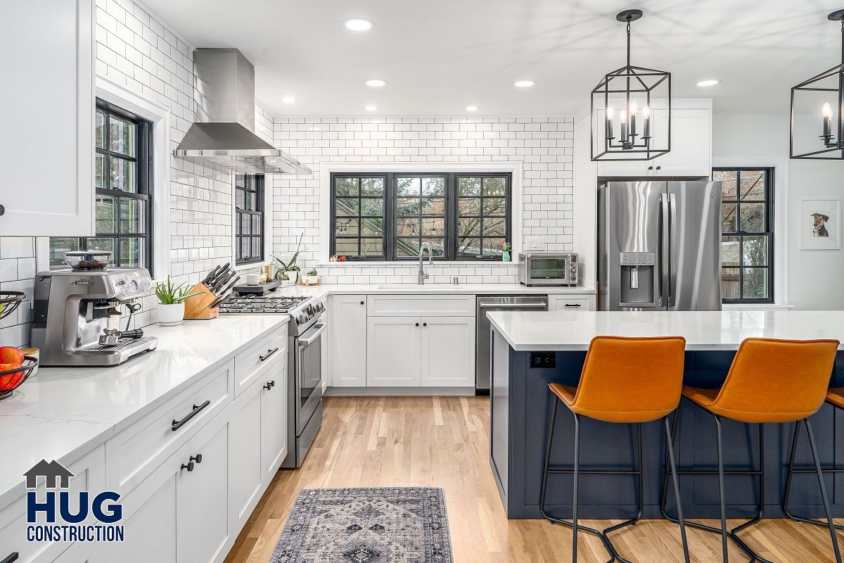 Modern kitchen remodels with stainless steel appliances, white cabinetry, subway tile backsplash, and a blue island with orange bar stools.