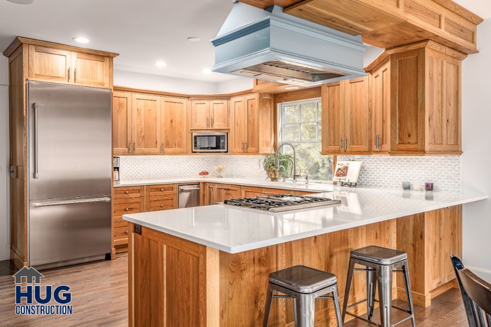 Modern kitchen interior with wooden cabinets, stainless steel appliances, remodels, and an island with seating.