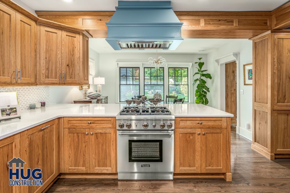 A modern kitchen remodels with wooden cabinets, stainless steel appliances, and a blue ceiling accent.