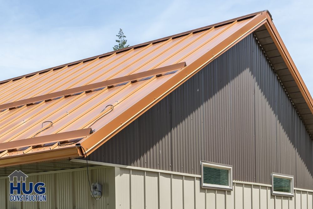 A metal roof on a building with the logo of Hug Construction visible, showcasing recent remodels and additions.