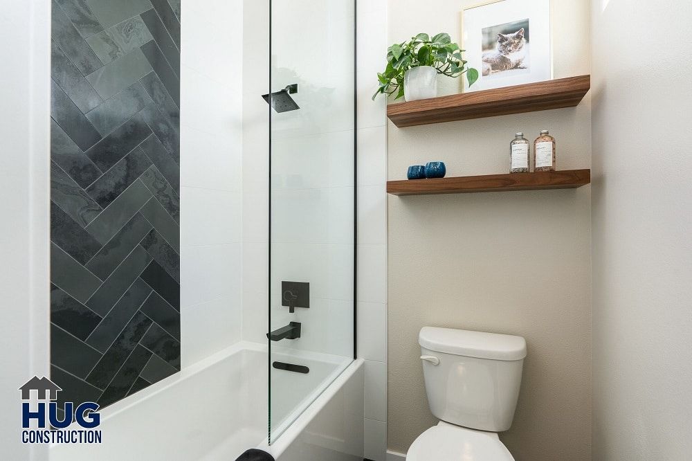 Modern bathroom remodels with walk-in shower, floating shelves, and a white toilet.