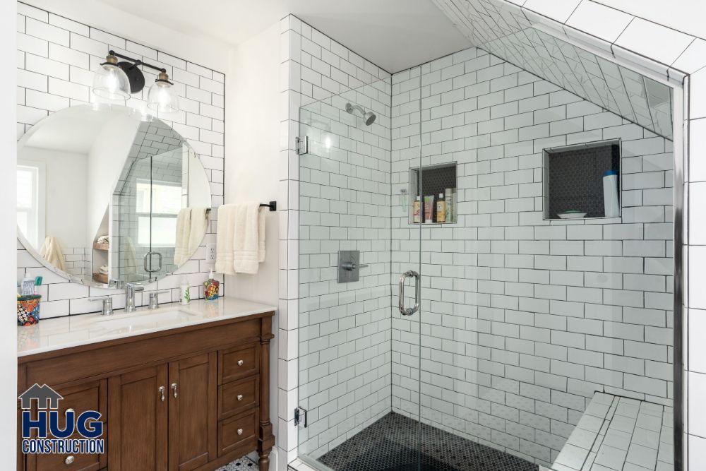 Modern bathroom remodels feature white subway tiles, a glass-enclosed shower, and a wooden vanity.