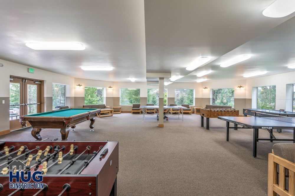 Spacious recreation room designed by a Commercial Contractor in Spokane, featuring pool tables, foosball, and table tennis.