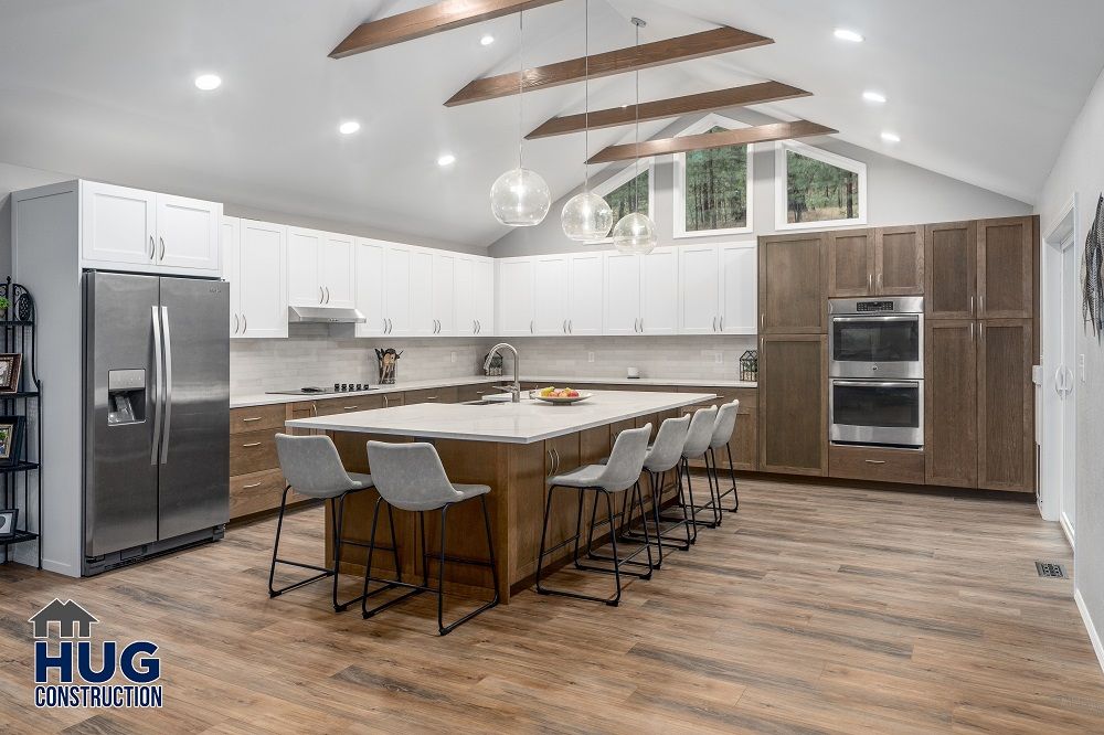 Modern kitchen remodels with white cabinets, stainless steel appliances, and a central island with bar stools.