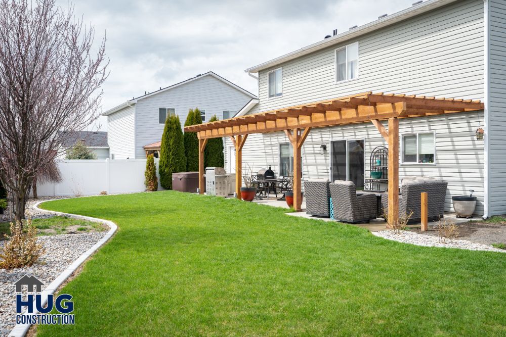 Suburban backyard with remodels including a wooden pergola and patio furniture.