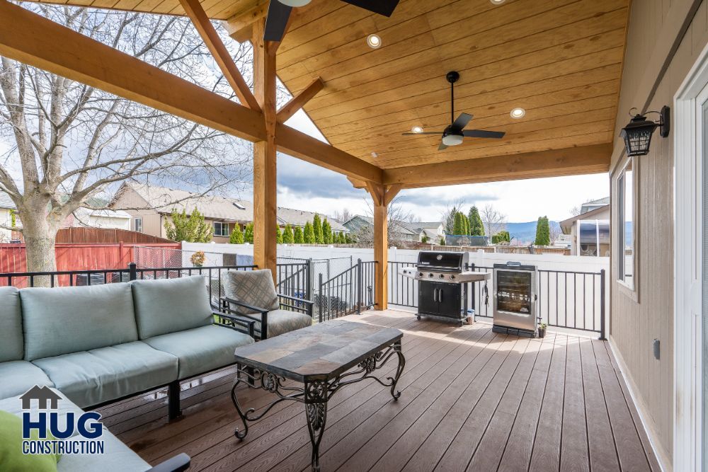 Spacious covered patio area with remodels and additions including outdoor seating, kitchen, and ceiling fans.