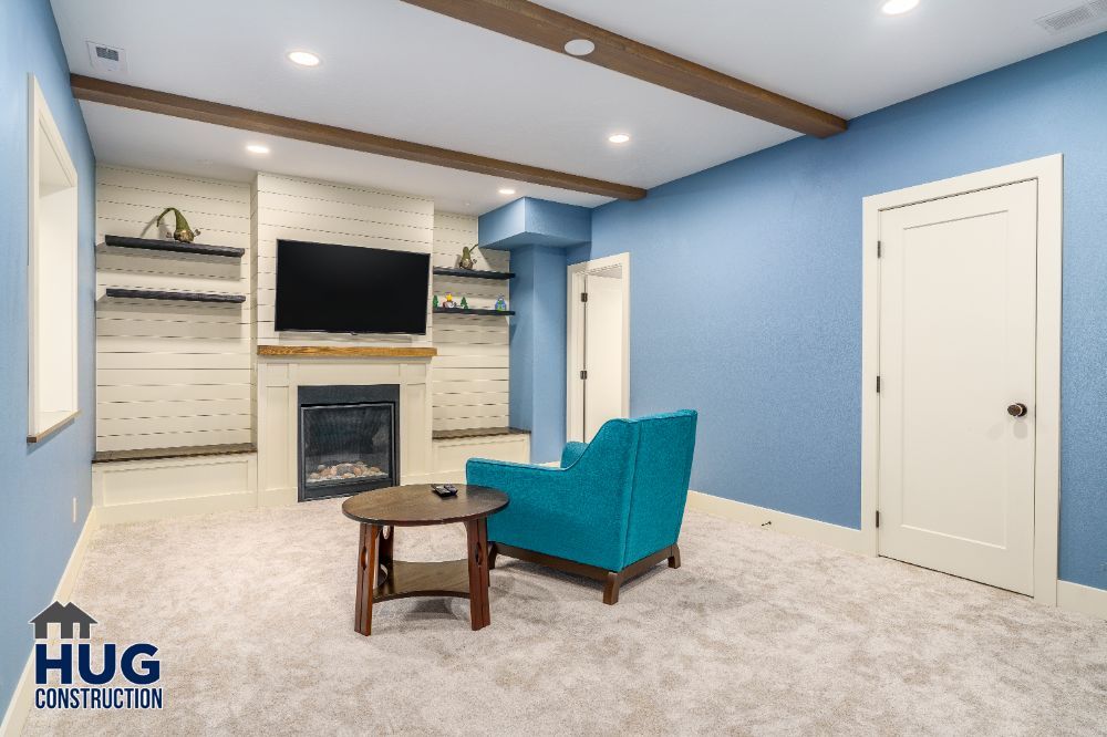 Cozy living room remodels with a blue accent chair, fireplace, and mounted television.