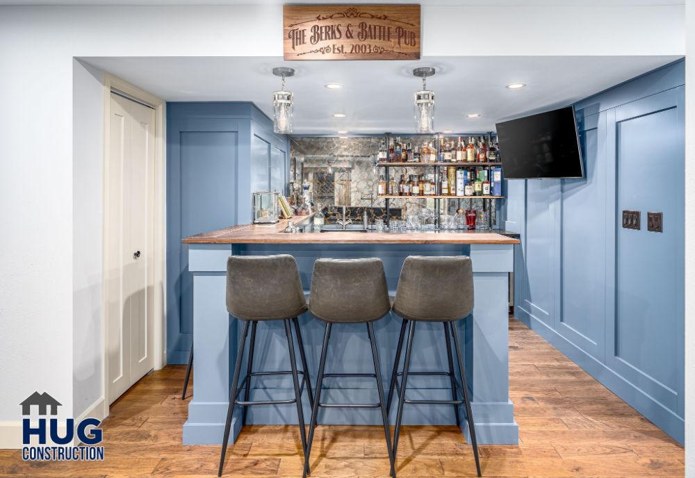 A modern home bar with blue accents, plush seating, and stylish additions.