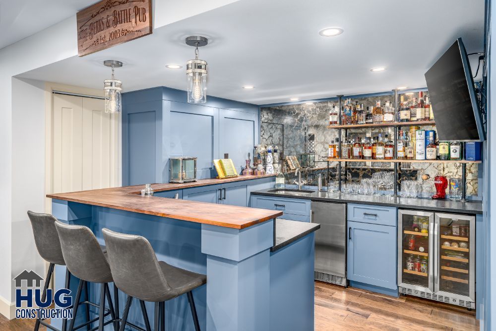 Modern home bar remodels with blue cabinetry and wooden countertop.