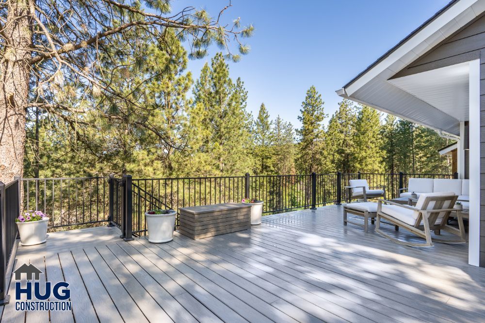 Spacious outdoor deck with comfortable seating and recent additions overlooking a forested area.