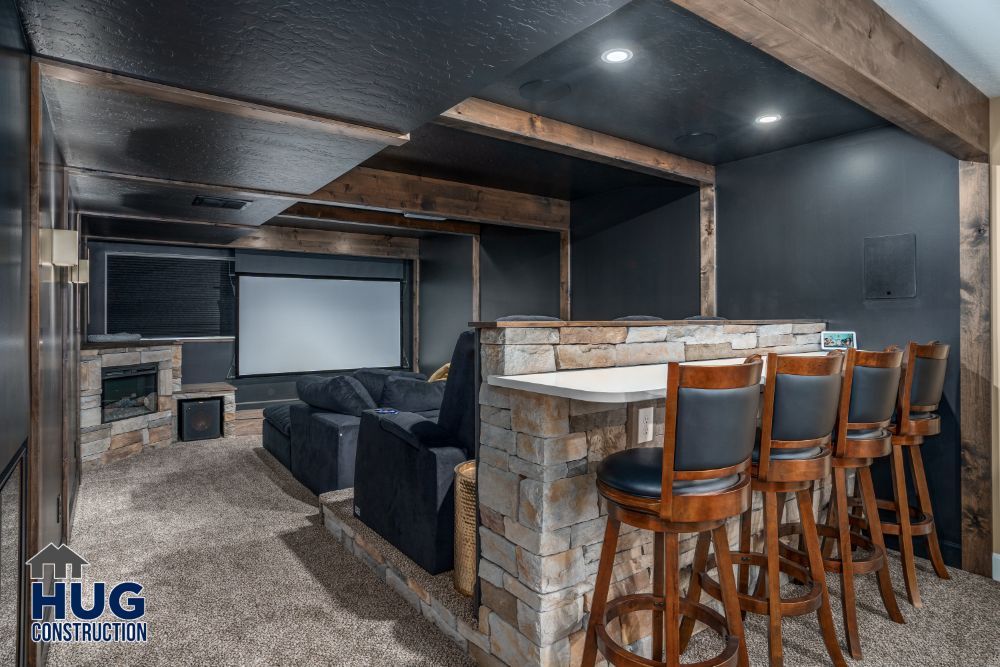 Modern basement remodels with home theater, bar seating, and projection screen.