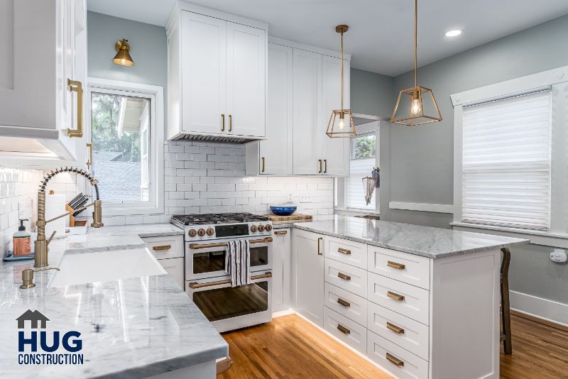 Bright and modern kitchen remodel with white cabinetry, stainless steel appliances, and pendant lighting.