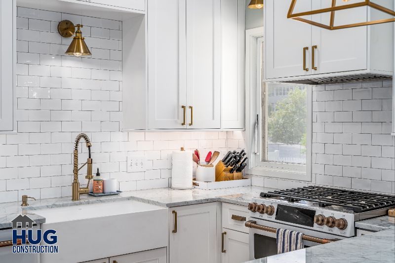 Modern white kitchen with stainless steel appliances, subway tile backsplash, and sleek remodels.