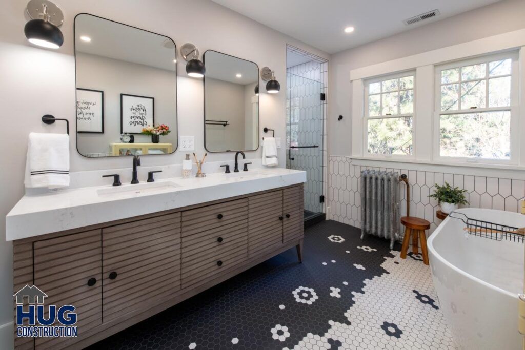 Modern bathroom interior with remodels and additions, featuring a double vanity, freestanding bathtub, and blue hexagonal tile flooring.