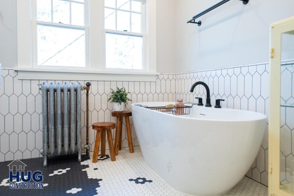 Modern bathroom remodels with a freestanding tub, hexagonal tile flooring, and a vintage-style radiator.