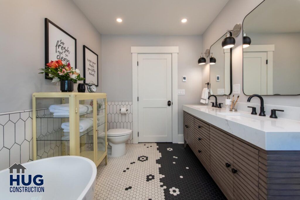 A modern bathroom with dual vanity sinks, decorative floor tiles, and elegant lighting fixtures benefitting from recent remodels and additions.