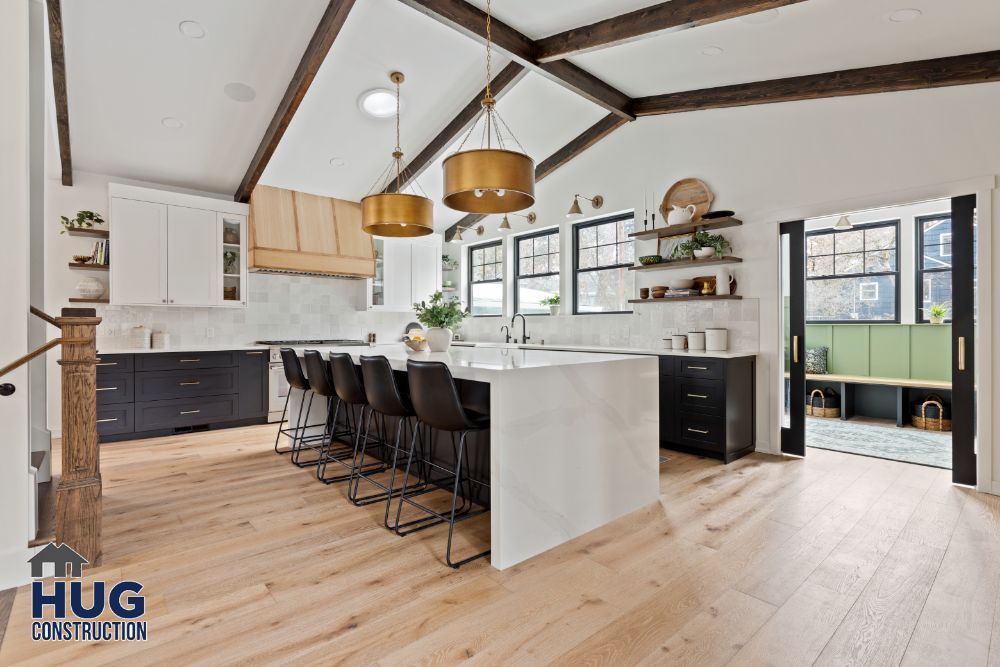 Modern kitchen remodels feature a mix of white and dark cabinetry, brass pendant lights, and a central island with bar stools.