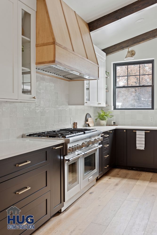 Modern kitchen remodels with dark cabinets, stainless steel appliances, and a wooden range hood.