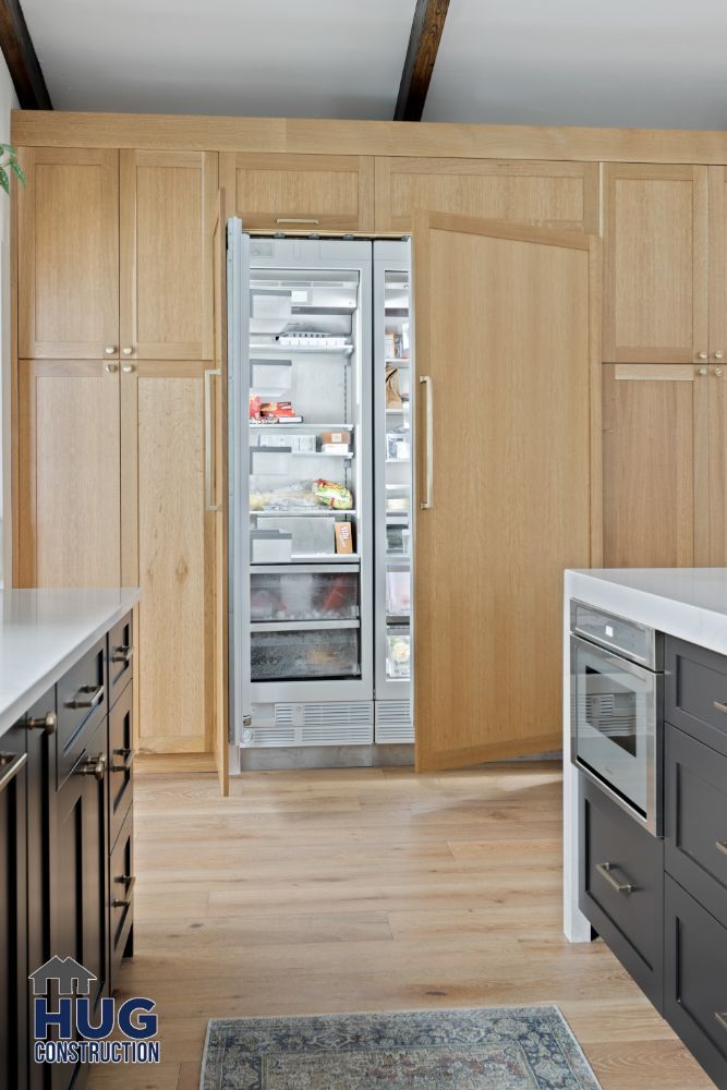 Modern kitchen remodels with wooden cabinets and an open stainless steel refrigerator.