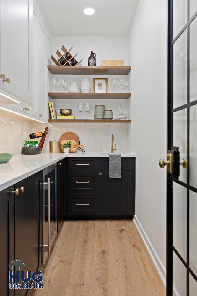 Modern kitchen pantry remodels featuring black cabinets, wooden floors, and open shelving with utensils and decor items.