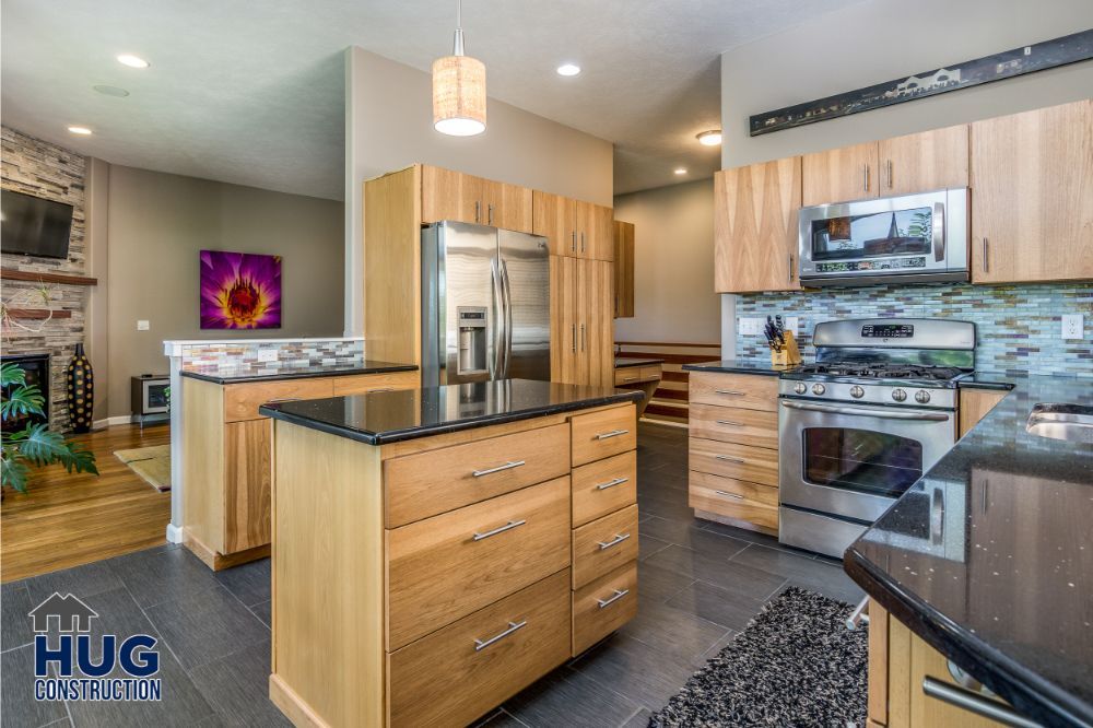 Modern kitchen interior remodels with stainless steel appliances and wood cabinetry.