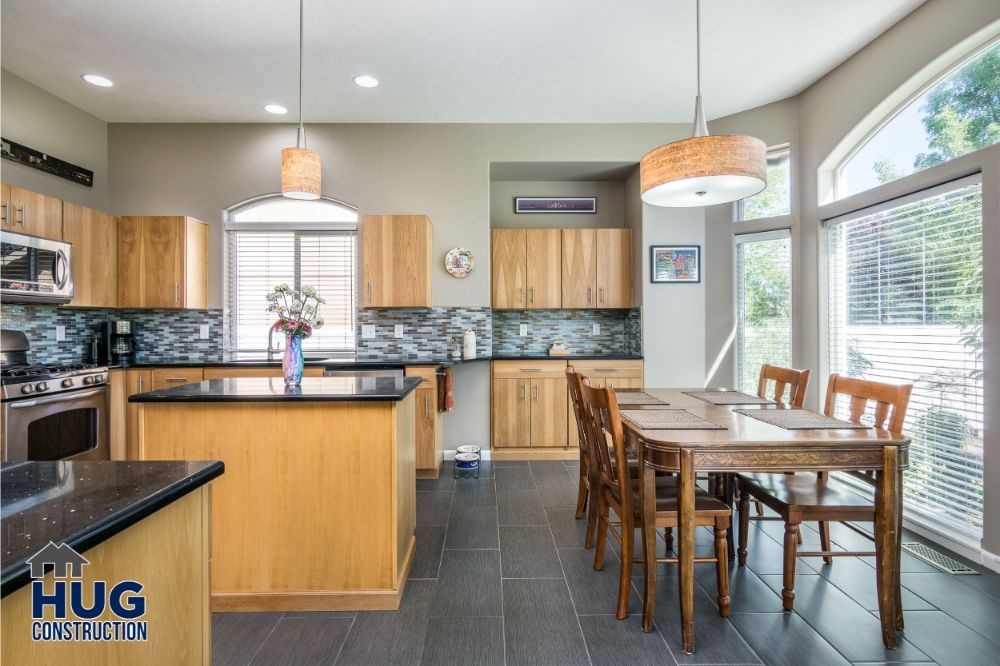 Modern kitchen with wooden cabinets, stainless steel appliances, remodels and additions including a dining area with a large window.