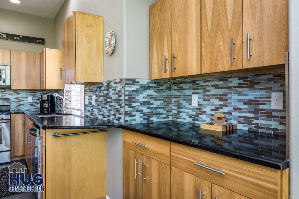 Modern kitchen remodels with wooden cabinets and mosaic backsplash.