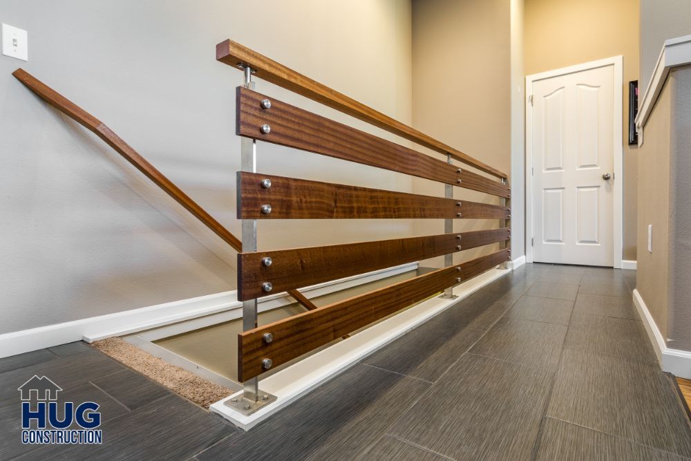 Modern staircase with wooden banisters and metal railings in a residential home, featuring recent remodels and additions.
