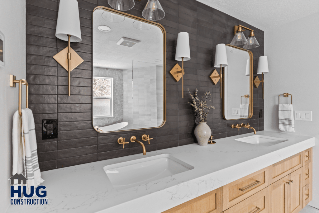 Modern bathroom from the Gunning Rd Interior Remodel featuring a double vanity with white countertops, rectangular vessel sinks, wooden cabinets, and black tile backsplash with two mirrors and brass fixtures.