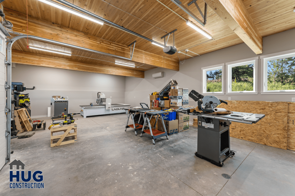 A spacious and well-organized workshop at Radio Ln Garage & ADU with various woodworking tools and machinery, featuring ample natural light and a wooden ceiling.