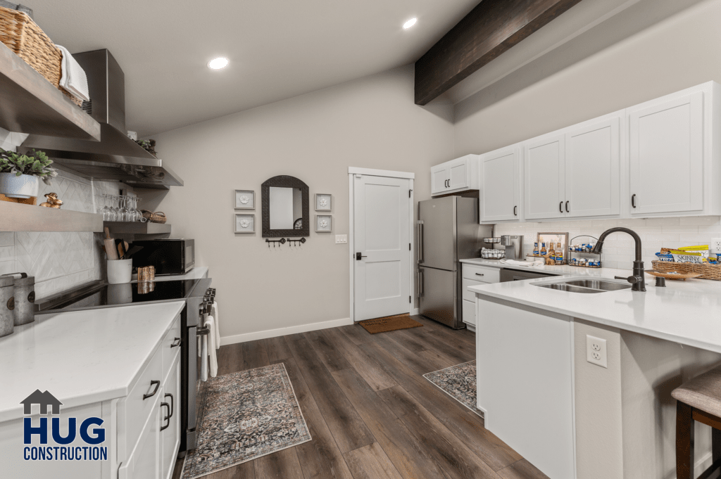 Modern kitchen interior with white cabinetry, stainless steel appliances, wooden accents, and Radio Ln Garage & ADU.