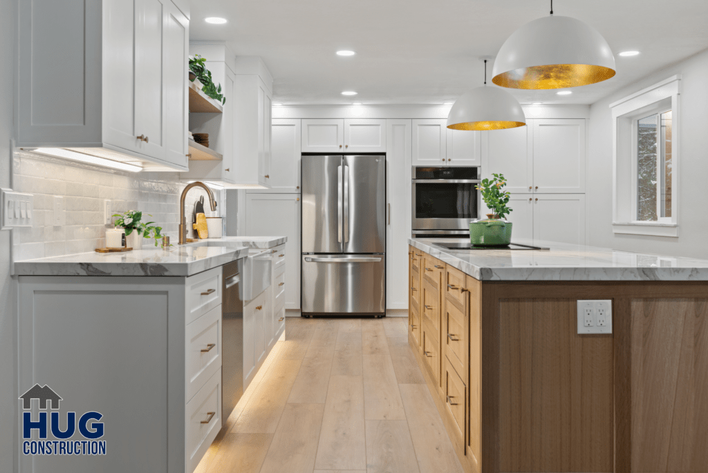 A modern Gunning Rd Interior Remodel kitchen featuring white cabinetry, stainless steel appliances, and an island with a wooden base and marble countertop.