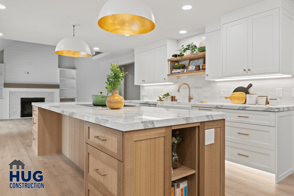 Modern kitchen interior with white cabinets and marble countertops on Gunning Rd, featuring pendant lighting with golden interiors and wooden accents.