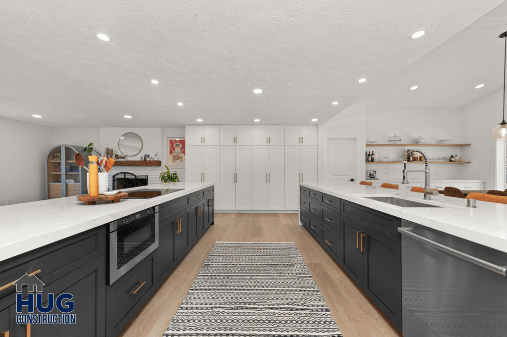 A modern kitchen remodel with white countertops, dark cabinets, and stainless steel appliances, featuring a central island and wooden flooring.